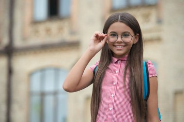 Okula dönelim. Eğitim ve bilgi. Bilgi toplama günü. Ortaöğretim. Eğitici vizyon. Kampüste gözlüklü bir kız. Okulun açık havada okuyan genç bir kız. 1 Eylül.