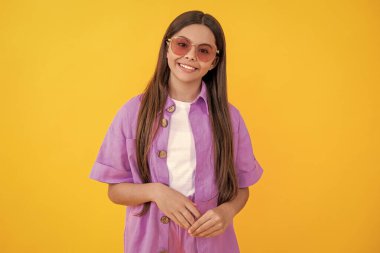 Stüdyoda uzun saçlı, şık bir genç kız. Şık yaz kıyafetleri içinde genç bir kız. Yazın şık giyinmiş genç bir kız. Yazın şık giyinen genç kız sarıya bürünmüş havanın tadını çıkarıyor..