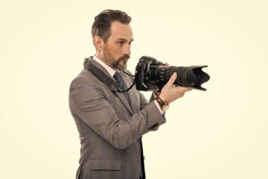 Kameralı iş fotoğrafçısı. Gazeteci, beyazın üstünde tek başına fotoğraf çekiyor. Paparazzi fotoğrafçı. İş adamı fotoğraf makinesini tutar. iş elbisesi içindeki foto muhabiri.