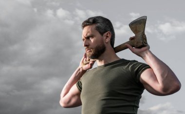 confident man with axe. caucasian man hold hatchet. brutal man on sky background.