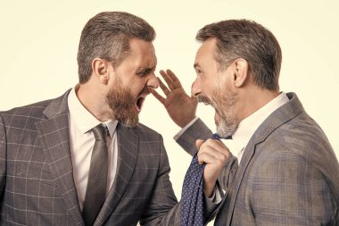 Stüdyoda tartışan iş adamları. Tartışan işadamları bağırıyor. Öfkeyle tartışan iş adamlarının fotoğrafı. Beyaz arka planda münakaşa eden iki işadamı.