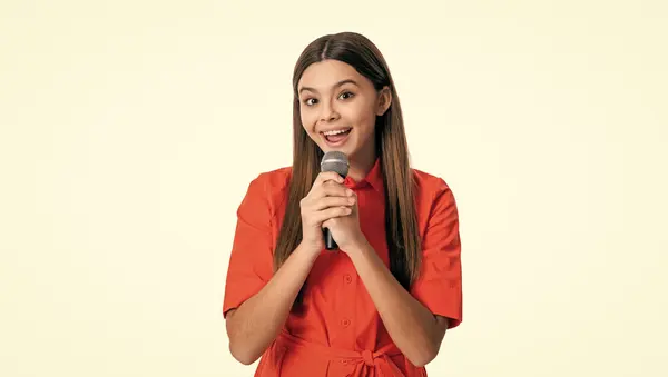 stock image amazed teen girl singer singing with microphone isolated on white. teen girl singer holding microphone in studio. teen girl singer with singing microphone. photo of singer teen girl hold microphone.