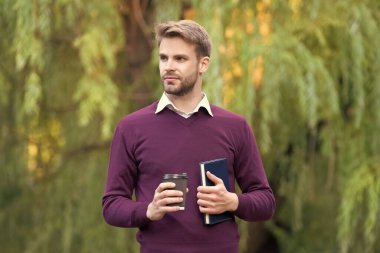 Genç yakışıklı adam dışarıda kahve molası veriyor..