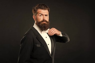 Smokin papyonlu ciddi bir adam. Siyah arka planda resmi giyinen bir adam. erkek resmi moda.