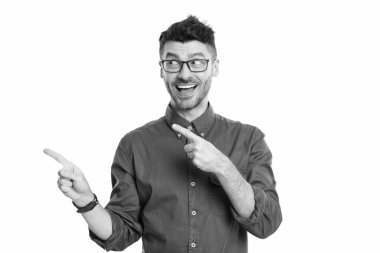 Şaşırtıcı yönetmen beyaz arka planda. Gözlüklü yönetmen. Yetişkin yönetmen tişört giyiyor. Kafkasyalı yönetmen stüdyoyu işaret etti.