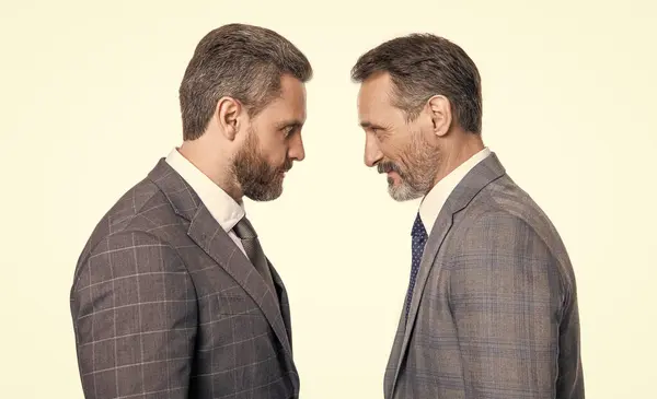 stock image businessmen having rivalry in studio. rivalry of mature businessmen in suit. photo of businessmen has rivalry look at each other. rivalry of two businessmen isolated on white background.