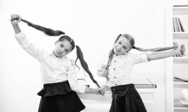 Çocuklar klasörü tutuyor. Lise eğitimi. Kızlar için okul eğitimi. Çocuk kızlar masanın üstünde. Okul dersine hazırım. Okuldaki iki kız. Eğitim ve bilgi. neşeli ruh hali.