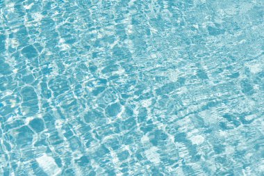 Havuz kenarında su yüzeyi olan bir tatil köyü. Mavi havuz arka planında deniz dalgaları. Deniz arka planı. Yüzme havuzu dalgalandı. Yaz tatili. Yaz tatilinde spa merkezi. Plaj tatili.