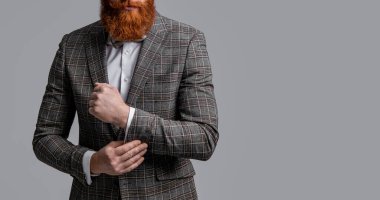 Erkek giyim smokinli kızıl saçlı adam. Erkekler şık erkek kıyafetleri giyer. Resmi takım elbiseli sakallı adamın zarafeti. Smokinli erkek giysili adam Griler 'de izole edilmiş. Kesilmiş görünüm ve kopyalama alanı.