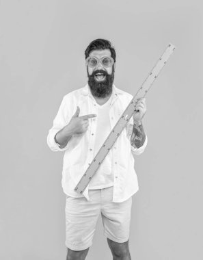 Cetvel tutan adamın fotoğrafı, stüdyoda sarıyı gösteren işaret parmağı..