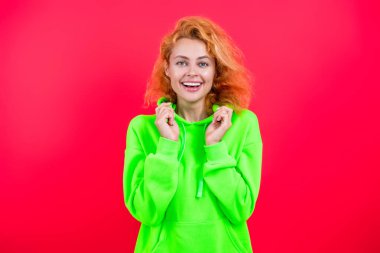 Tarz sahibi beyaz kadın ya da kızıl saçlı manken. Pembe üzerine izole edilmiş şık ve modaya uygun kapüşonlu parlak renk..