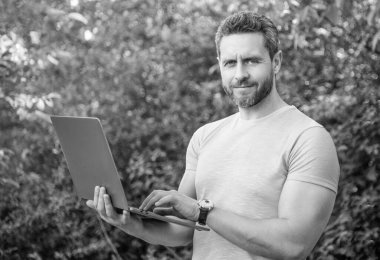 Gülümseyen adamın internette işi var. Adamın internette işi var. Adamın bilgisayarda işi var. İnternette iş yapan bir adamın fotoğrafı..