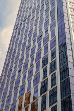 Gökdelen mimarisi. Camsı yüzlü bir gökdelen. Modern şehir binası. Metropolis City 'de bir gökdelen. Şehir merkezinde gökdelenli bir şehir. Ofis binası dış tarafı.