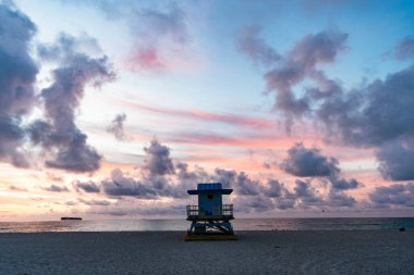 Miami Florida sahilinde cankurtaran kulübesi. Miami South Beach 'te güneş doğarken sahildeki cankurtaran istasyonu. Miami, South Beach 'teki cankurtaran kulesi. Yaz tatili günbatımı. Gün doğumu.