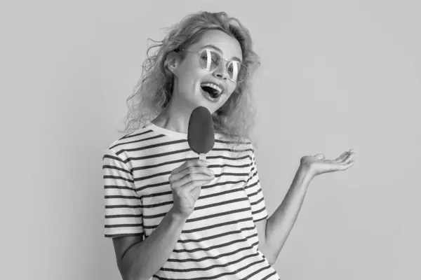 stock image glad girl with delicious ice cream in studio. girl with delicious ice cream on background. photo of girl with delicious ice cream at summer. girl with delicious ice cream isolated on yellow.