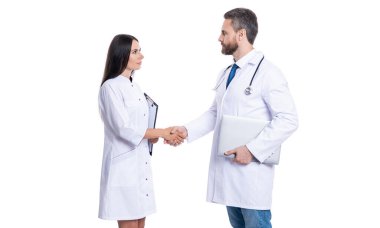 İki doktor beyazın üzerinde el sıkışıyor. Tokalaşma, hasta sağlığı konusunda anlaşma. Hastane takım çalışması işbirliği. Başarılı tedavi. Doktor, hemşireyle tokalaşıyor. El sıkışma anlaşması.