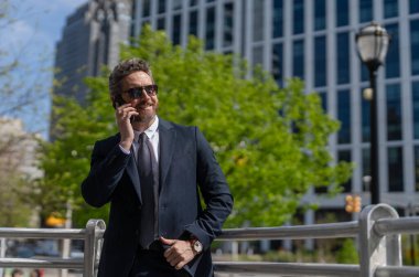 İş adamının dışarıyı araması gerekiyor. Telefon kullanan bir iş adamı. Takım elbiseli bir adam telefonda konuşuyor. Telefonu olan orta yaşlı İspanyol işadamı. İş iletişimi. Reklam..