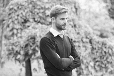 Havalı giyinen yakışıklı genç adam ellerini açık havada çapraz yaptı..