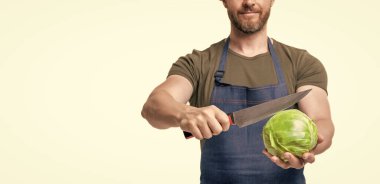 Önlüklü bir adam beyaz lahana kesti. kırpılmış görünüm.