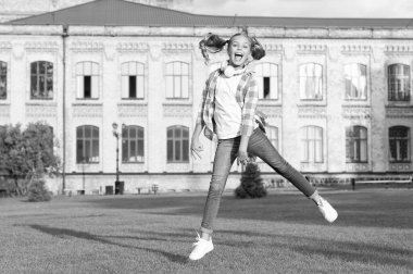 Happy active teen girl jumping in school yard outdoors, schooling.