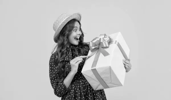 stock image surprised teen girl with present box on yellow background.