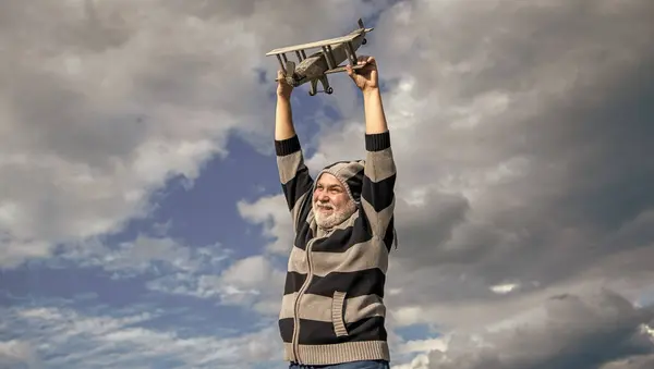 stock image happy retirement. retired granddad launch toy. retired old man outdoor. senior man at retirement on sky background.