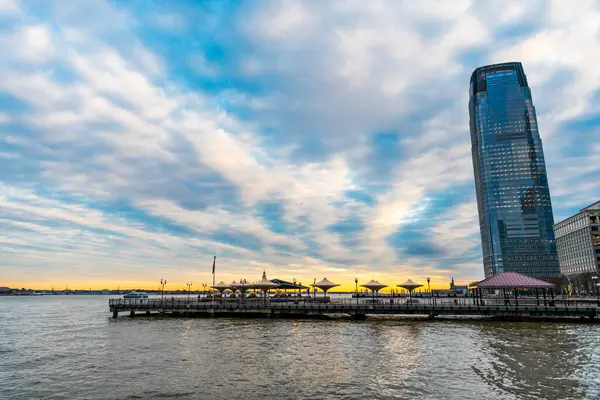 stock image New York, Jersey City, USA - December 20, 2023: Goldman Sachs Tower skyscraper building in NJ New Jersey skyline with outdoor cafe.