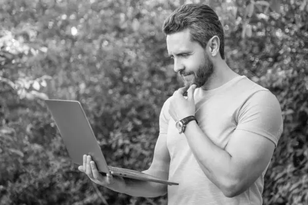 stock image positive man has business online on laptop. photo of man has business online. man has business online. man has business online outdoor.