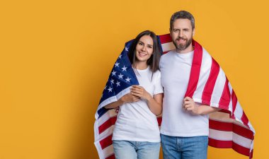Bir çift Amerikan bayrağıyla gururla poz veriyor, fotokopi uzayı. Amerikan bayrağı taşıyan çiftlerin vatanseverliği. Bayrağa sarılı Amerikalı ruh çifti kutluyoruz. Bayrağı olan Amerikalı çift..