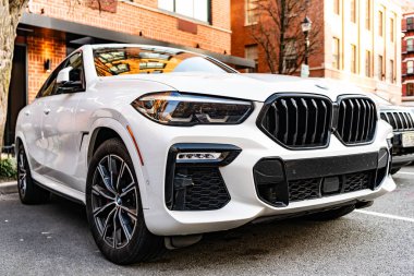New York, ABD - 15 Mart 2024: BMW X6 modern beyaz araba açık havada, köşe manzaralı.