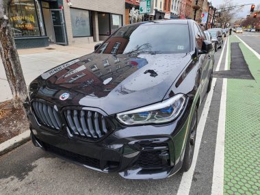 New York City, ABD - 10 Mart 2024: BMW X6 araba siyah dışarıda, köşe manzaralı.