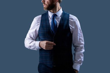 Gri üzerine izole edilmiş resmi bir etkinlikte şık kravatlı üç parça takım elbiseli şık bir iş adamı..