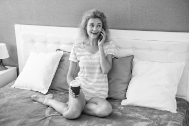 Telefonda kahve sohbeti yapan neşeli bir kadın. Evde telefonla konuşan bir kadın. Kadının evinde telefon konuşması..