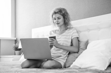 Evde dizüstü bilgisayarında kahve işi olan özenli bir serbest çalışan kadın. Serbest çalışan bir kadın evde çalışıyor. Serbest çalışan biri için ev işi. Yatakta dizüstü bilgisayarlı bir kadın.