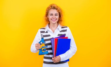 Kadınlar için biyoloji bilimi. Mikroskop araştırması. Okul biyoloji öğretmeni kadının elinde mikroskop var. Kadın biyoloji öğretmeni. Okula dönelim. Mikroskobu sarı olan öğretmen. Mikrobiyoloji çalış..