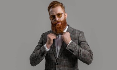 Formalite icabı smokinli adam gride tek başına. Formalite içinde smokin giyen kızıl saçlı adam. Erkekler şık erkek kıyafetleri giyer. Resmi takım elbiseli sakallı beyefendinin zarafeti. Resmi kıyafet. Zarif zarafet.