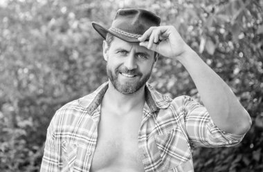 happy west man in cowboy hat. west cowboy in checkered shirt. western cowboy wearing west hat.