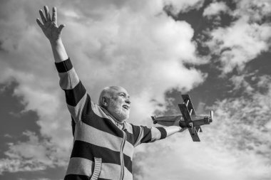 happy retirement. old granddad with toy. retired old man outdoor. senior man at retirement on sky background.