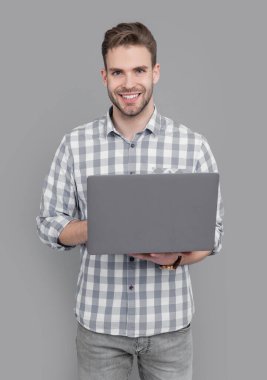 Üniversite öğrencisi online çalışmak için dizüstü bilgisayar kullanıyor. Dizüstü bilgisayar yazan mutlu bir adam. Online eğitim. Lise eğitimi.