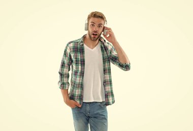 Stüdyoda müzik kulaklıklı adam şok oldu. Müzik kulaklıklı bir adamın fotoğrafı. Müzik kulaklıklı adam beyazda izole edilmiş. Arkadaki müzik kulaklıklı adam..