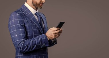 Akıllı telefondan iş adamlarının sohbetini izledik. Takım elbiseli akıllı telefondan iş adamı sohbeti. Akıllı telefondaki iş adamı sohbeti gri arka planda izole edilmiş. İş adamı akıllı telefon sohbetini kontrol et