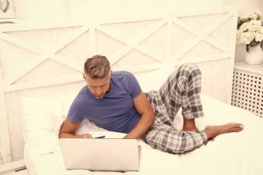 man freelancer at home. man freelancer at home in bed. man freelancer at home in bedroom. photo of man freelancer at home with laptop.