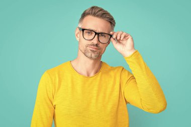 mature man look in eyewear on background. photo of man look in eyewear. man look in eyewear isolated on blue. man look in eyewear at studio.