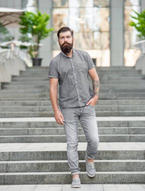 bearded hipster walking downstairs. full length of hipster with beard. hipster man outdoor.