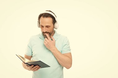 man reading elearning in headphones, copy space. man reading elearning in headphones on background. photo of man reading elearning in headphones. man reading elearning in headphones isolated on white. clipart