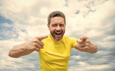 happy mature bearded man pointing finger outdoor.