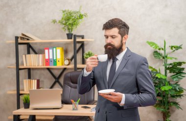 mature entrepreneur in jacket enjoying coffee break at office, guy.