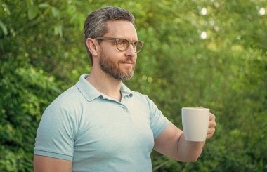 Neşeli adamın fotoğrafı kahvenin tadını çıkar. Adam kahveyi seviyor. Adam sabahları kahvenin tadını çıkarıyor. Adam dışarıda kahveyi seviyor..