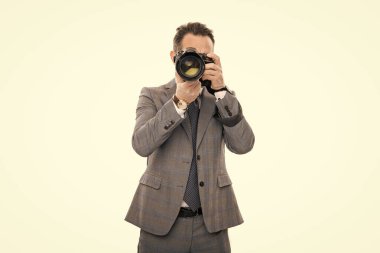 Gazeteci, beyazın üstünde tek başına fotoğraf çekiyor. Paparazzi fotoğrafçı. İş adamı fotoğraf makinesini tutar. Takım elbiseli foto muhabiri. Kameralı iş fotoğrafçısı. basın fotoğrafçısı.