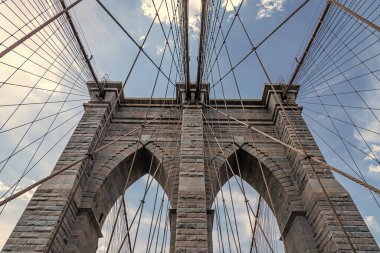 Metropolis 'teki Brooklyn Köprüsü' nün muhteşem manzarası. Brooklyn 'deki tarihi köprünün mimarisi. Amerikan mimarisi tarihi eser. Manhattan 'a giden yol. New York 'taki Brooklyn Köprüsü. şehir yapısı.